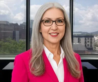Professional businesswoman in pink blazer representing The Concierge Office Suites in Chattanooga